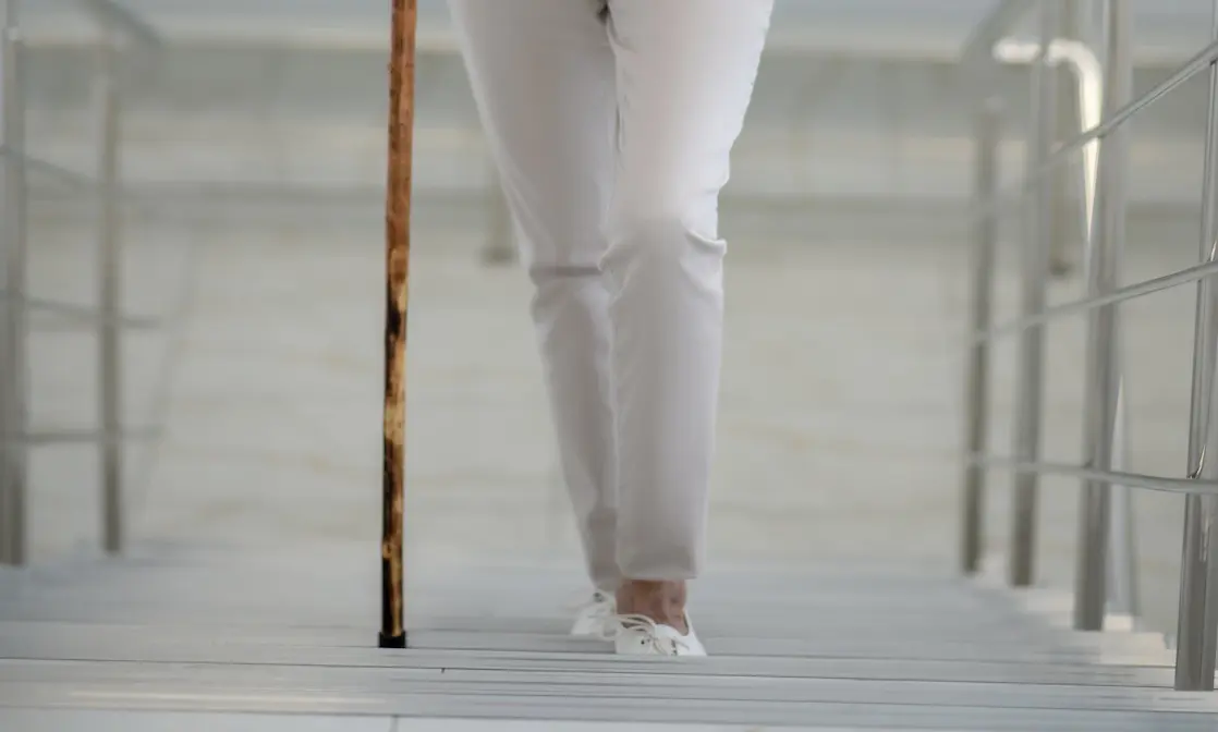 Spinalkanalstenose und Treppensteigen: Eine Frau geht Treppe rauf 